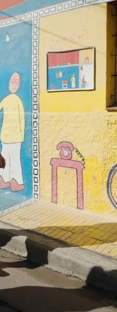 Two people walking past colorful mural street art