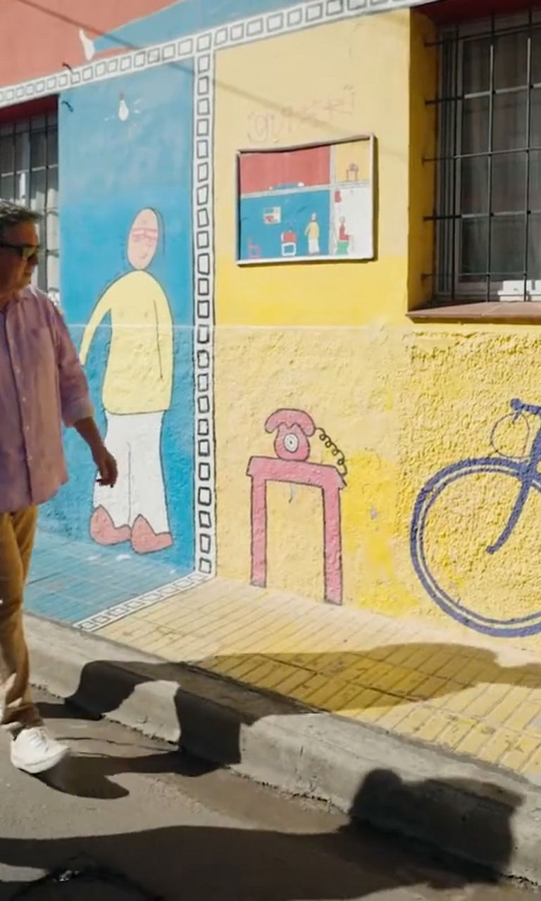 Two people walking past colorful mural street art