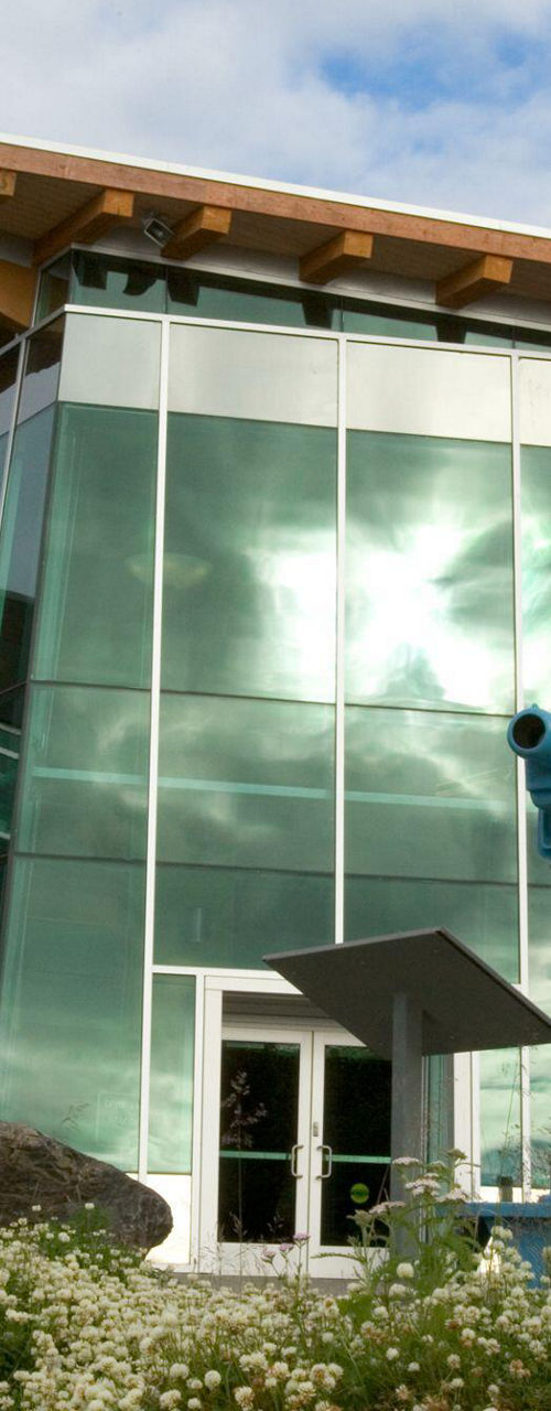 Modern building with outdoor telescope setup