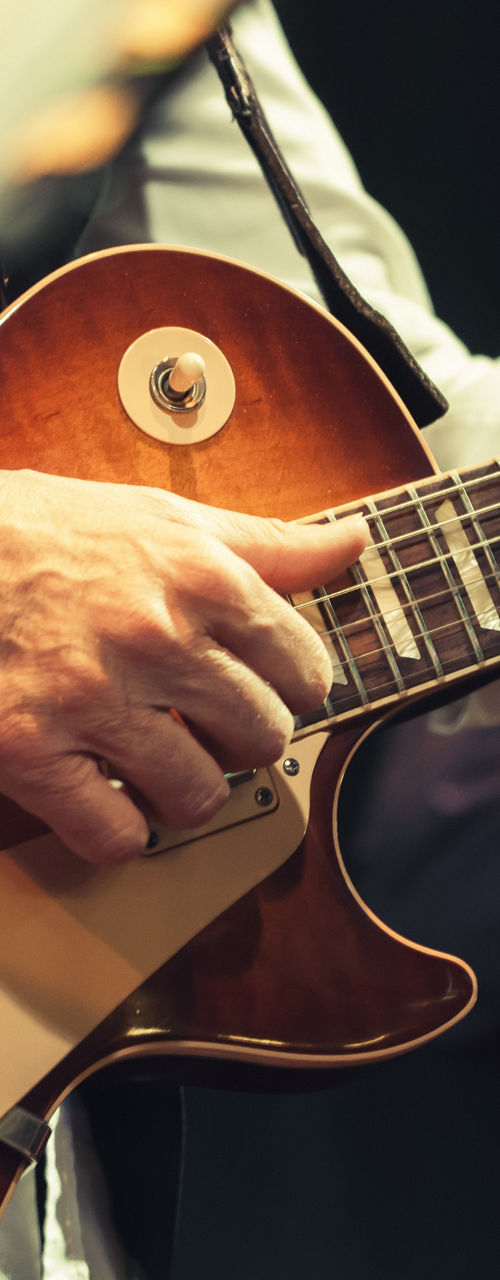 Close-up of guitarists performing live
