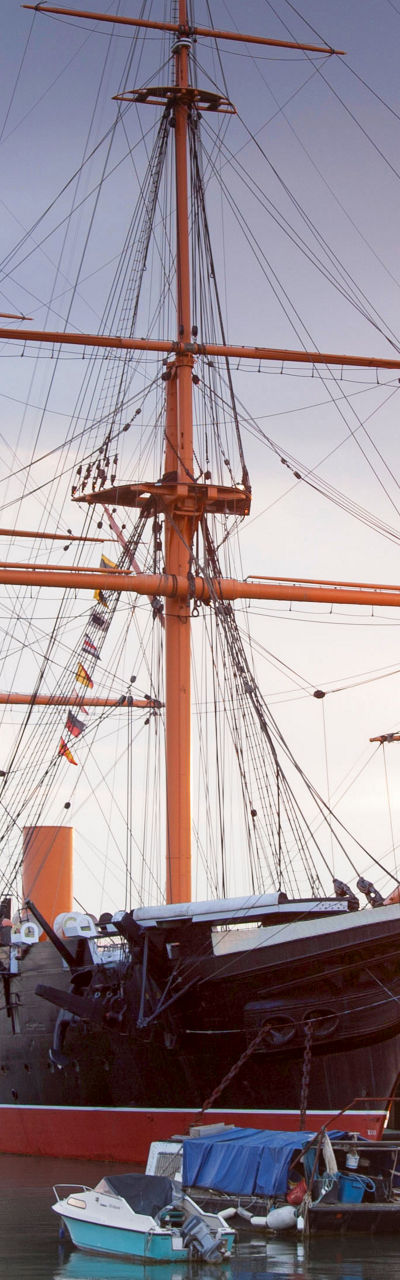 Historic ship docked at sunset harbor
