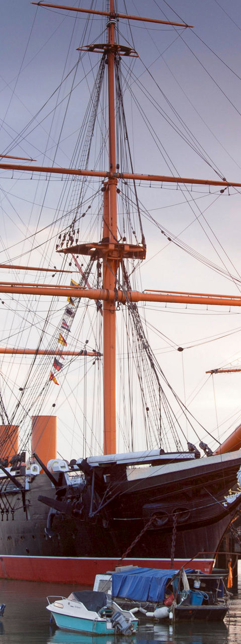 Historic ship docked at sunset harbor