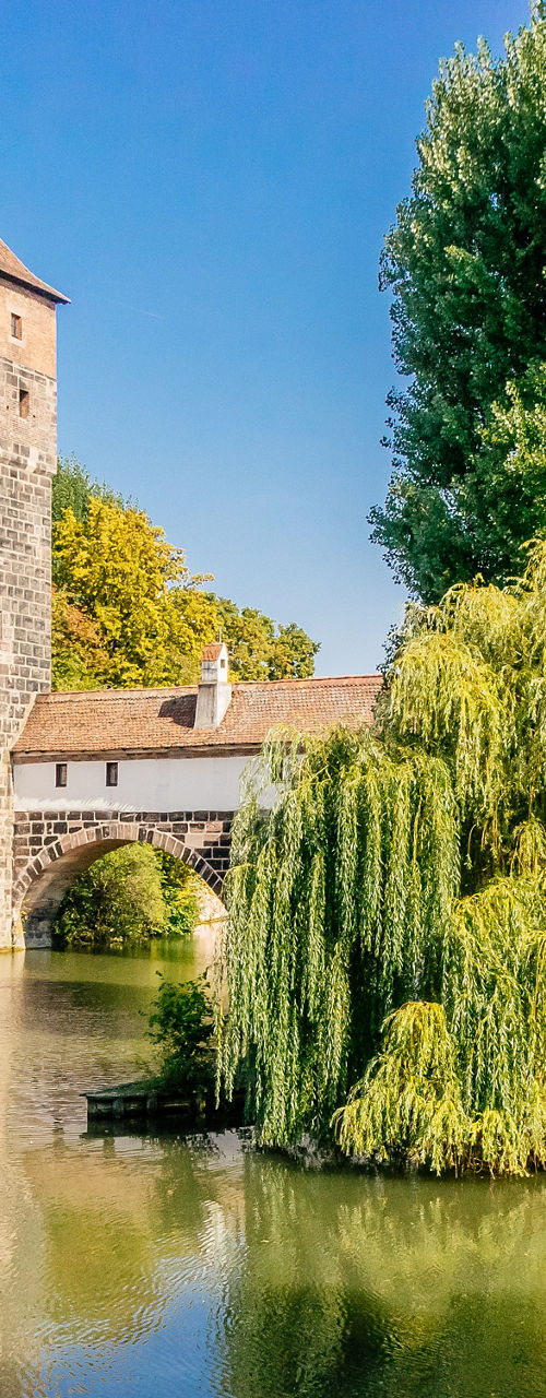 Historic tower by serene riverside landscape