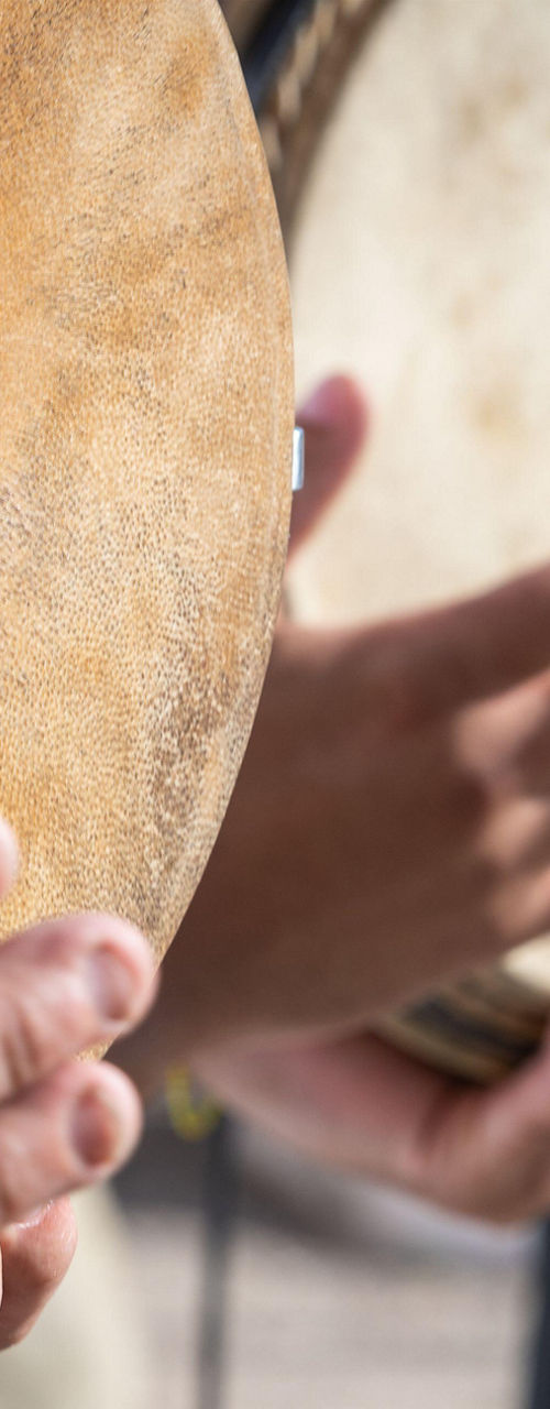 Hands playing traditional wooden drums