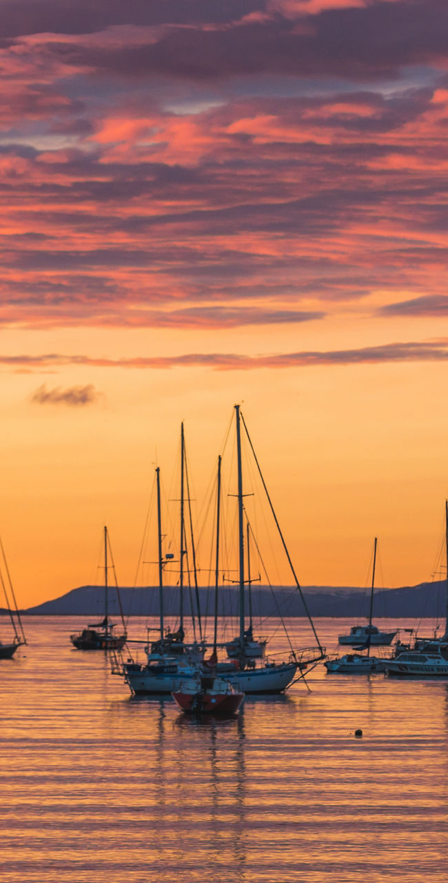 Sailboats at sunset on calm waters