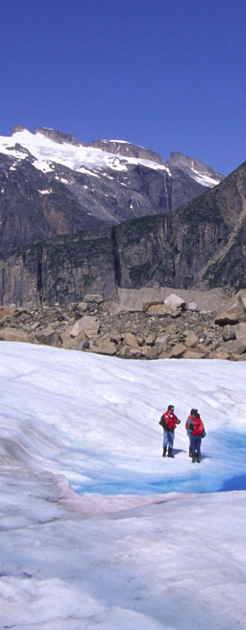 Helicopter landing on glacier with hikers