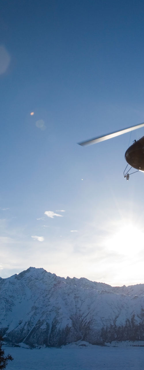 Helicopter flying over snowy mountain landscape