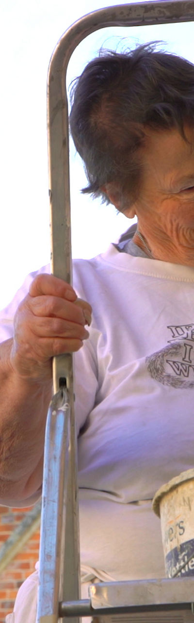 Person painting exterior near historic building