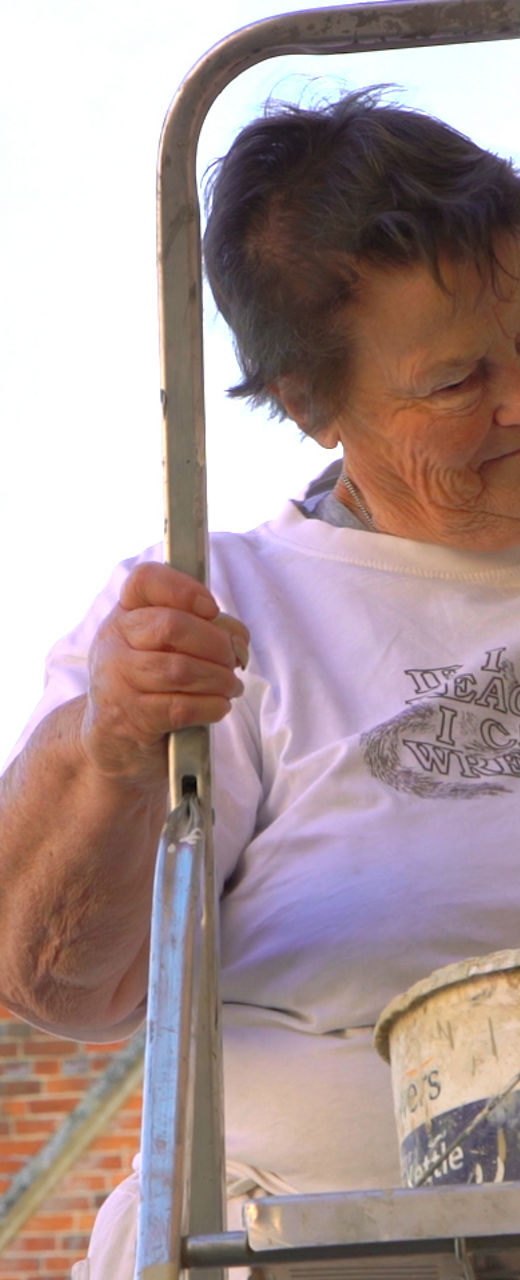 Person painting exterior near historic building