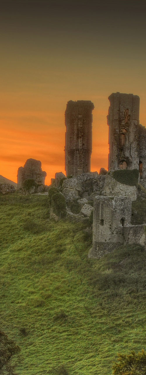 Sunrise over Corfe Castle ruins on hill