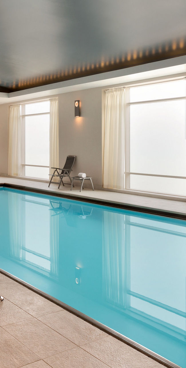 Modern indoor pool with lounge chairs