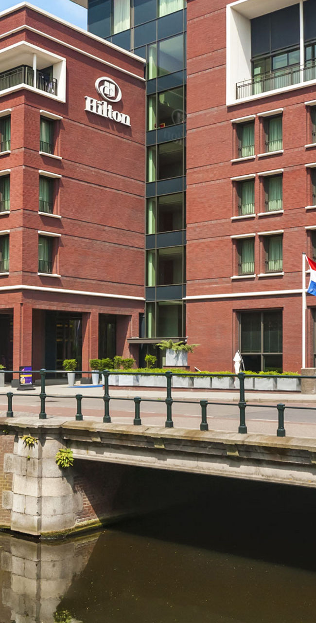 Hilton hotel building by canal in daylight