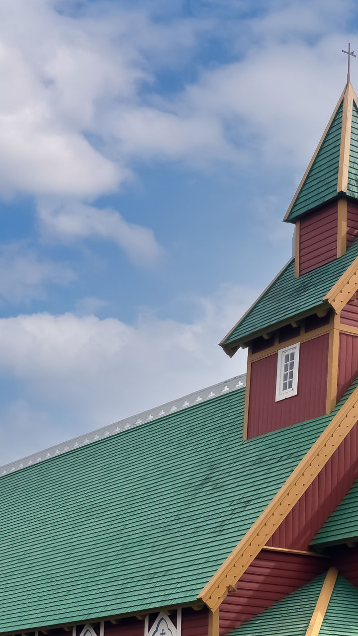 Red and green church in scenic landscape