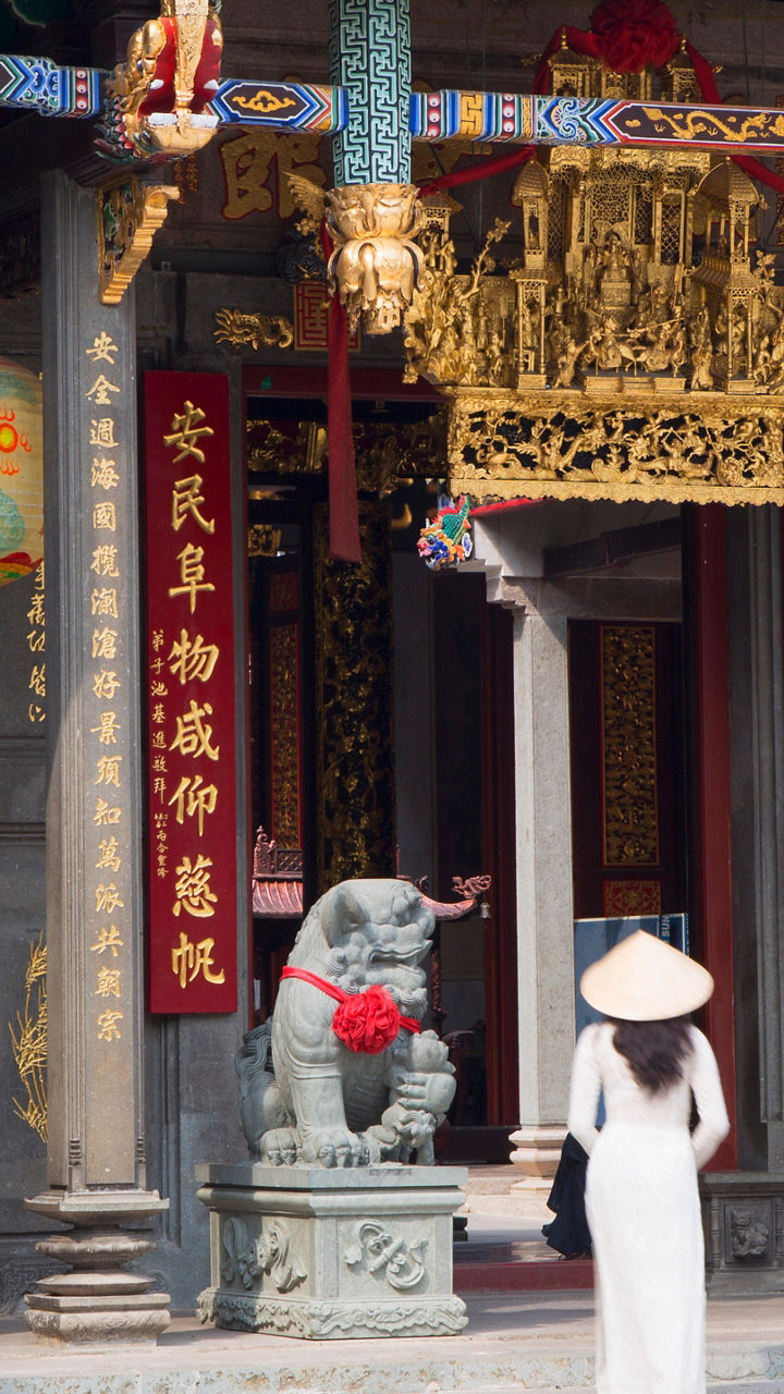 Woman entering ornate Chinese temple