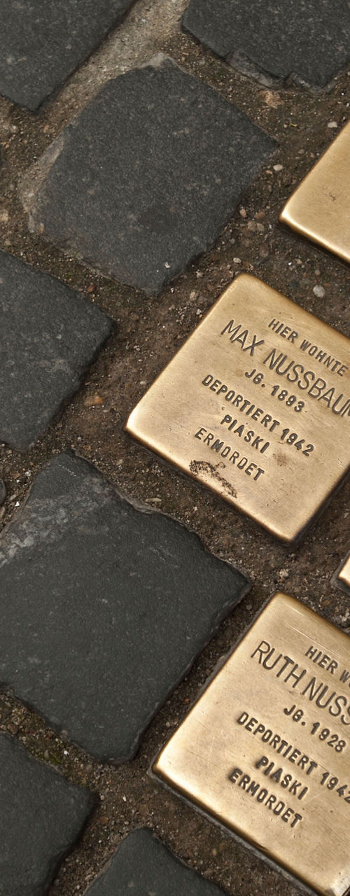 Brass memorial plaques on cobblestone street