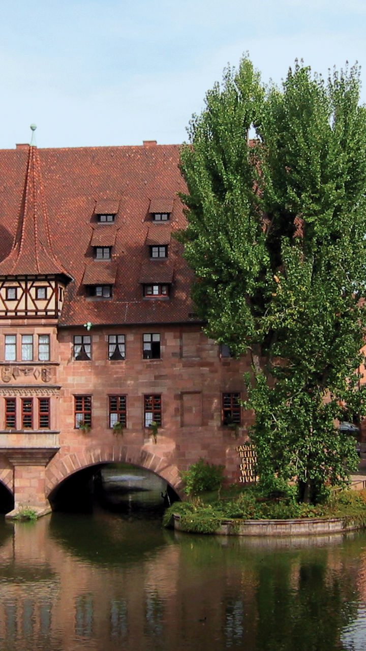 Historic riverside building with arched bridges