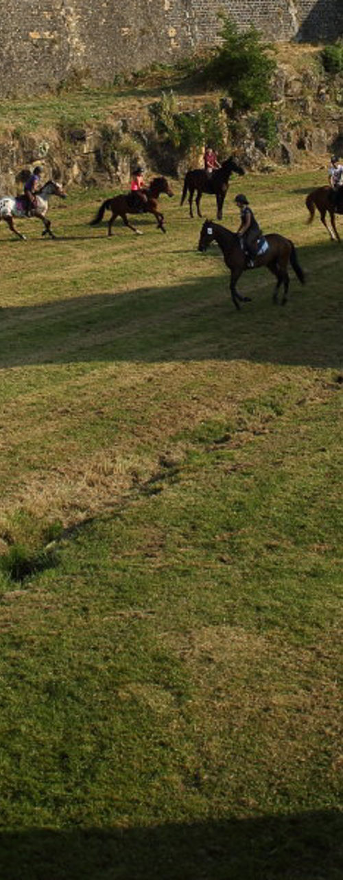 Horse riders near historic stone fortress