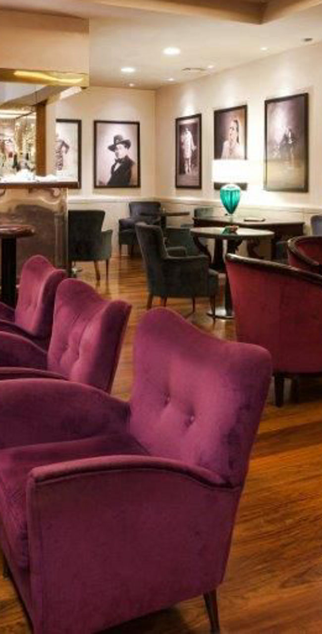 Elegant lounge with purple seating and portraits