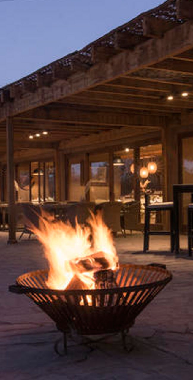 Outdoor patio with fire pits at dusk