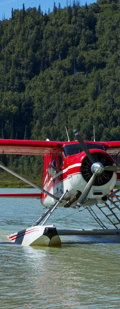 Red seaplane floating on mountain lake