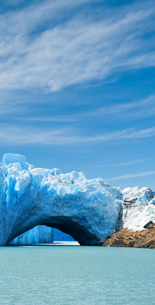 Majestic glacier with arch over turquoise water