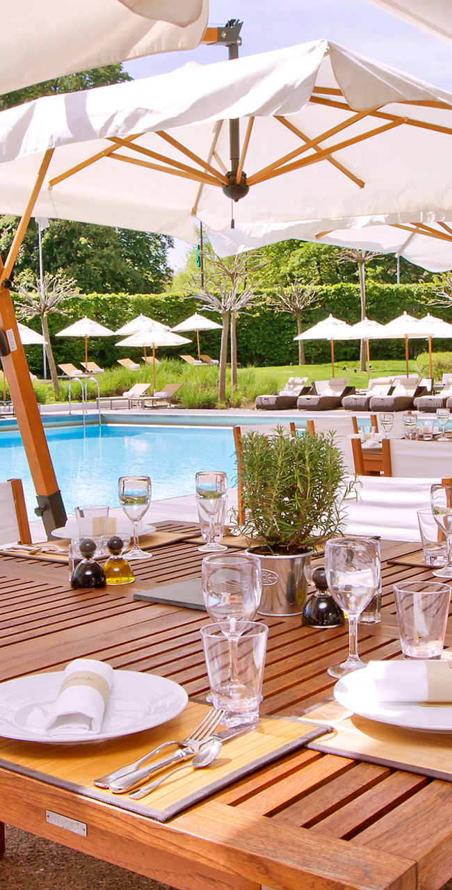 Outdoor dining by pool with umbrellas