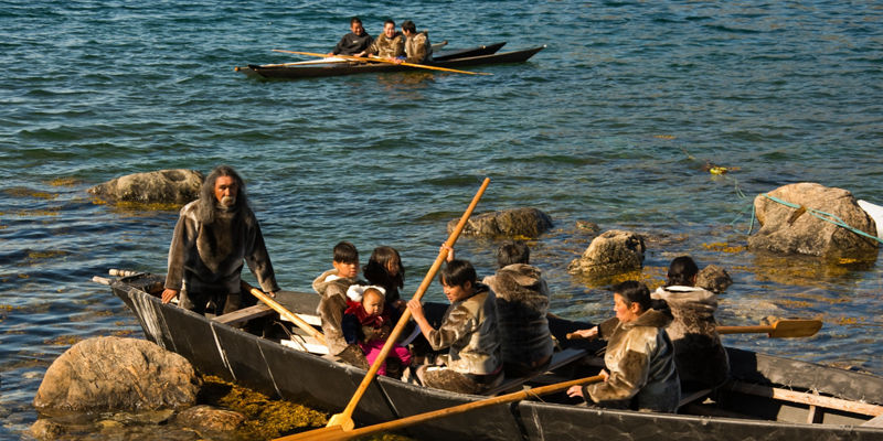 Traditional canoeing on rocky lake shore