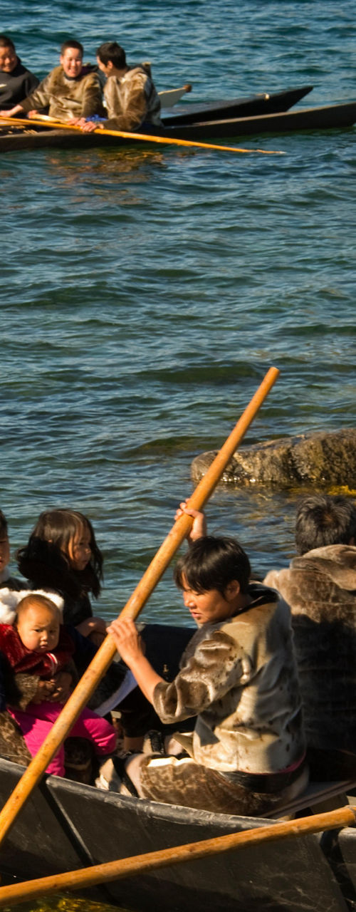 Traditional canoeing on rocky lake shore