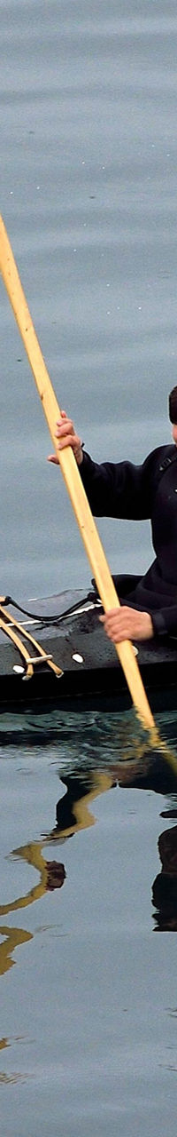 Person kayaking on calm water surface