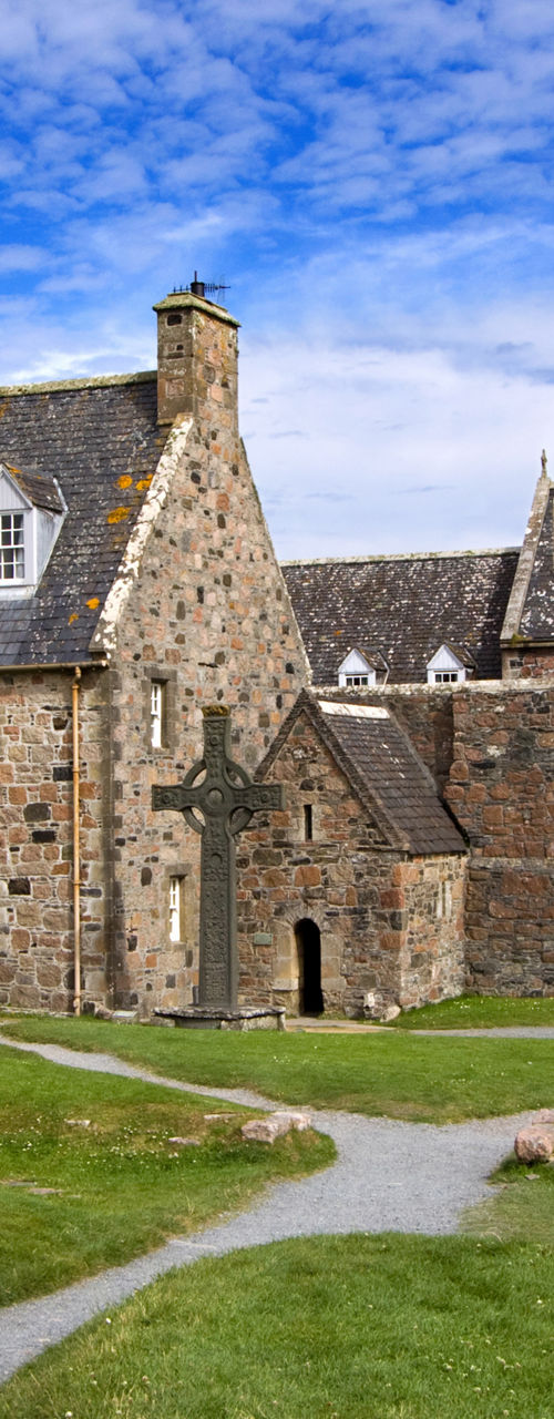 Historic stone abbey with cross in landscape
