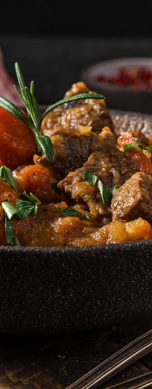 Rustic beef stew with vegetables on wooden table