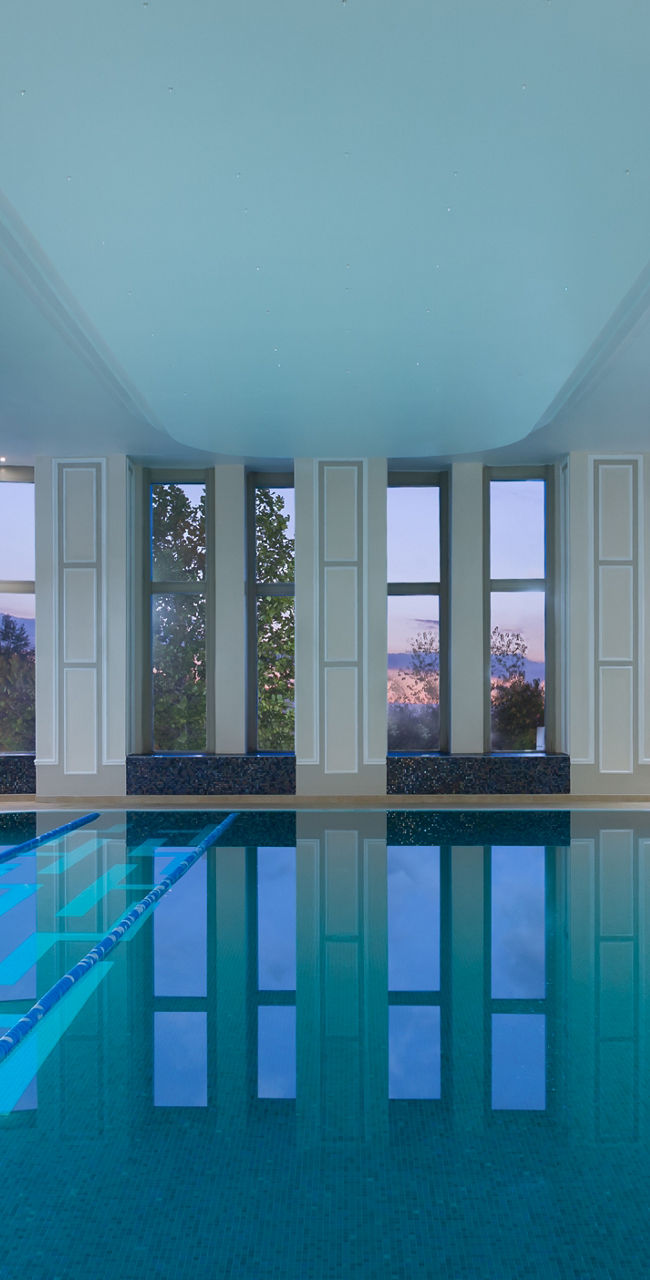 Elegant indoor pool with lounge chairs