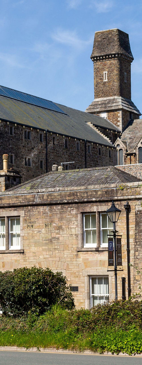 Historic stone building behind roadside wall