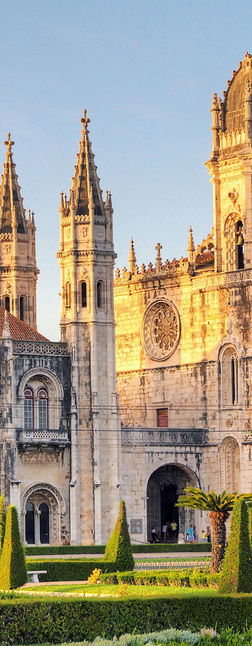 Historic monastery with formal gardens at sunset