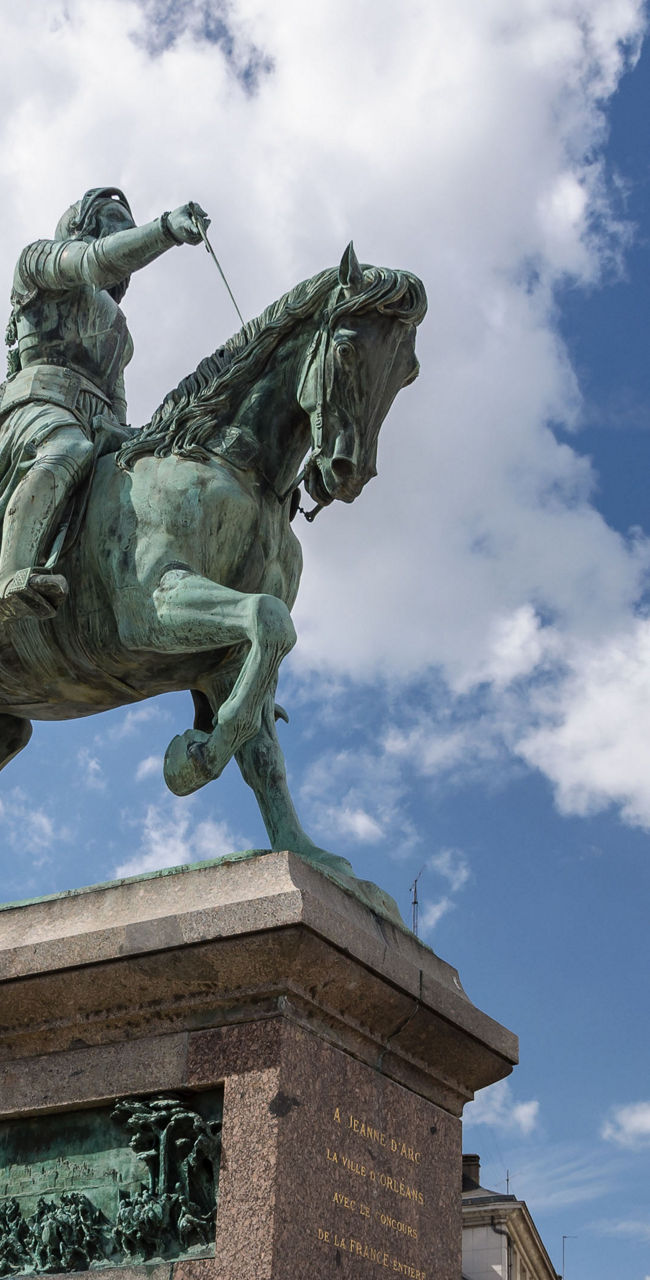 Equestrian statue in urban square under blue sky