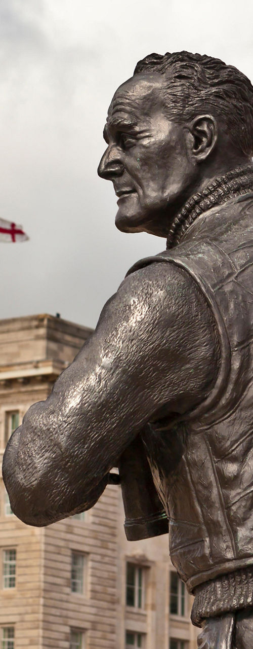 Bronze statue with historic architecture backdrop