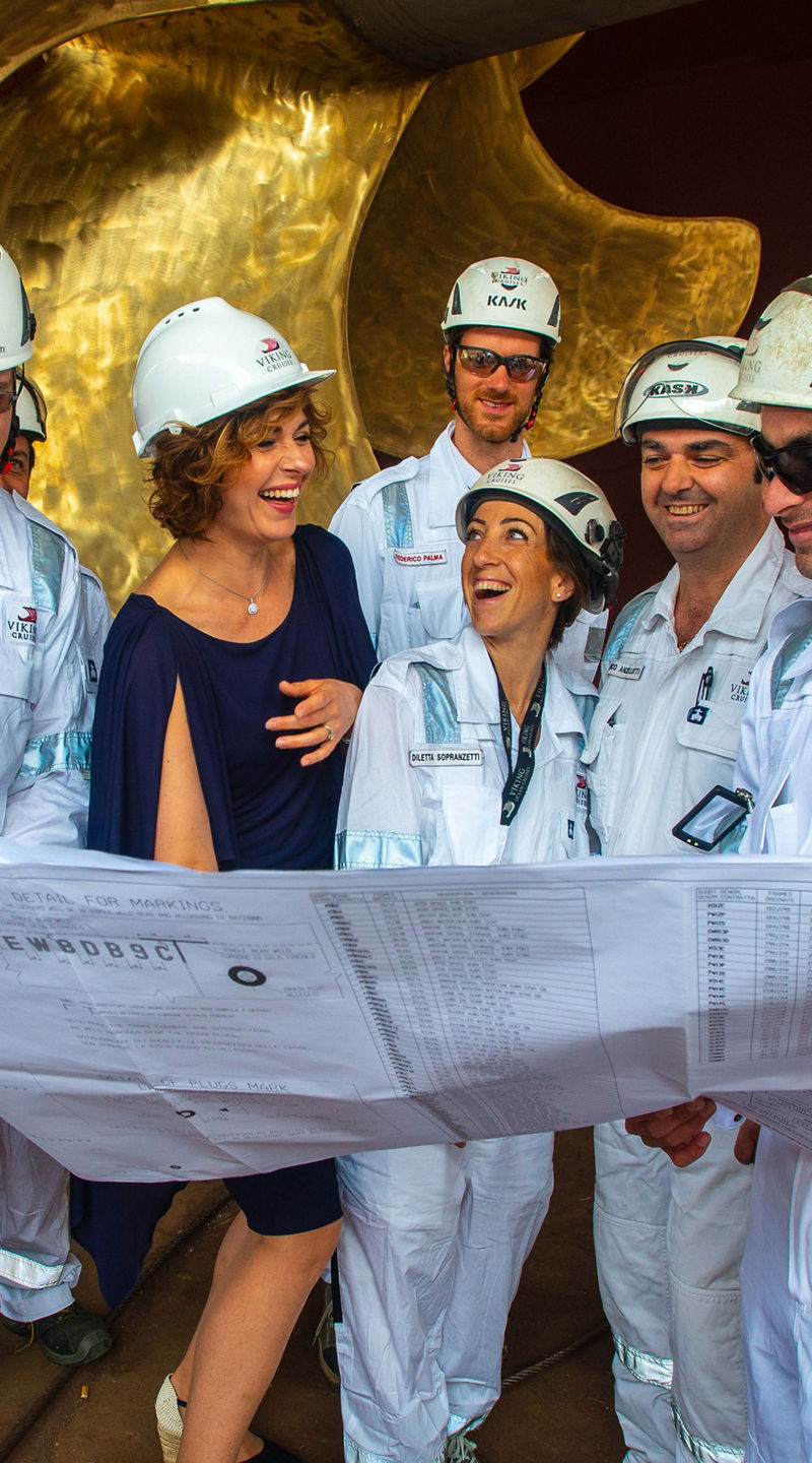 Engineers and supervisor review blueprints at shipyard