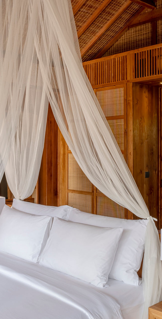 Tropical wooden bedroom with canopy bed