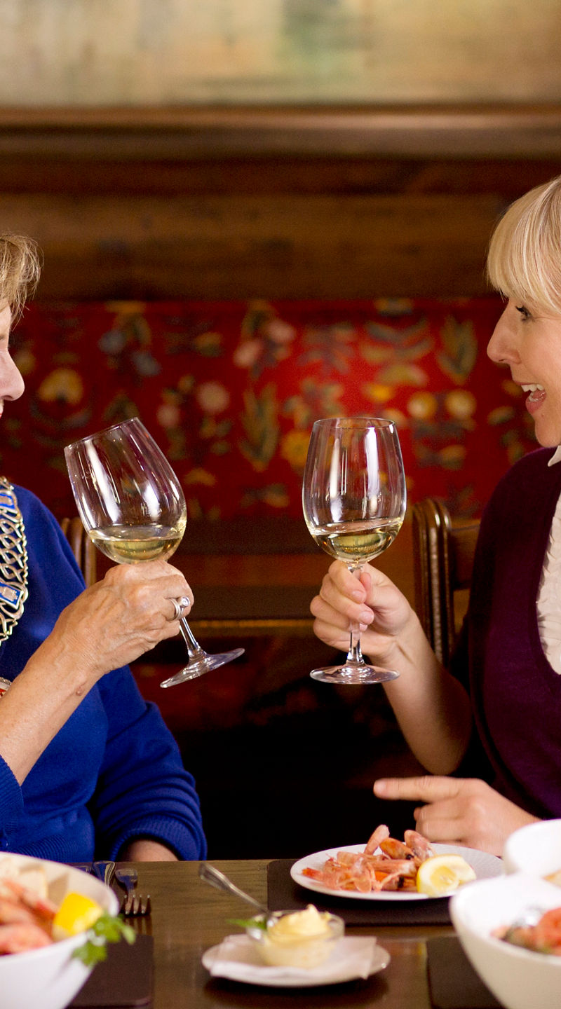 Two women toasting with white wine