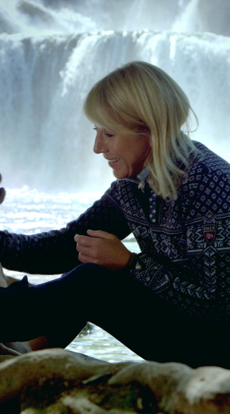 Woman with dog near waterfall outdoors