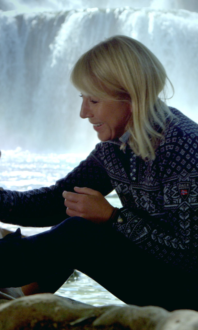 Woman with dog near waterfall outdoors