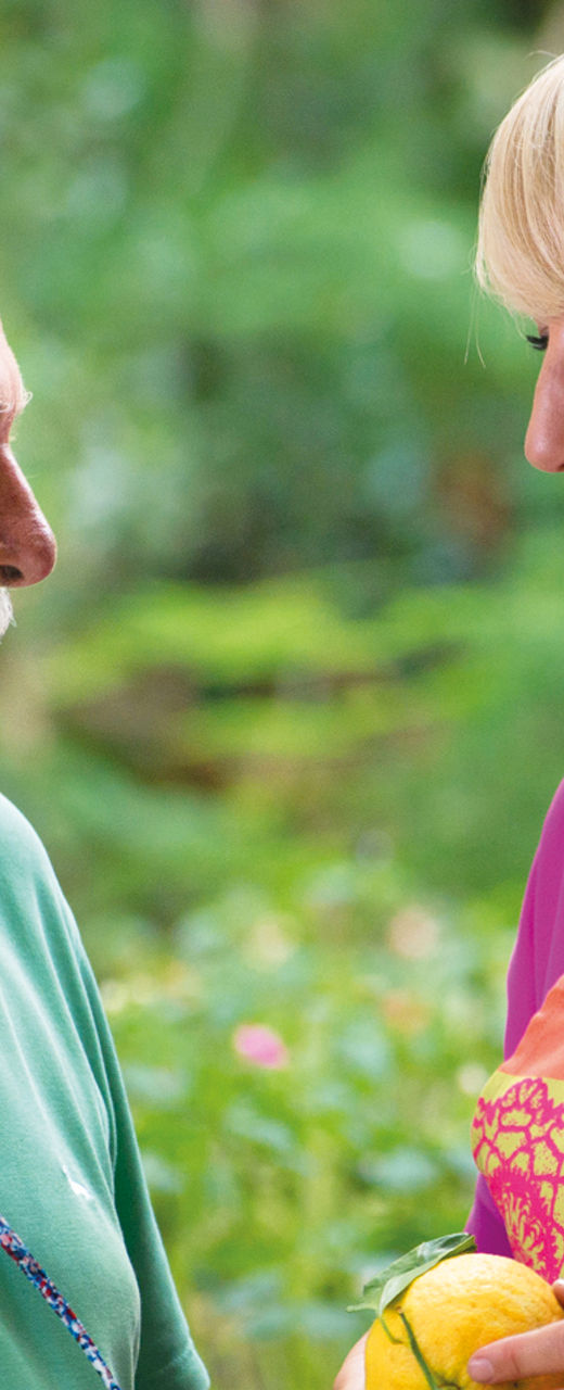 Two people interacting in a garden setting