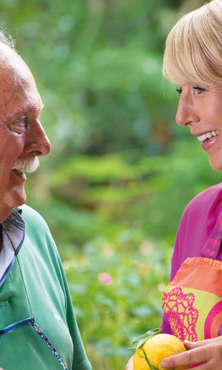 Two people interacting in a garden setting
