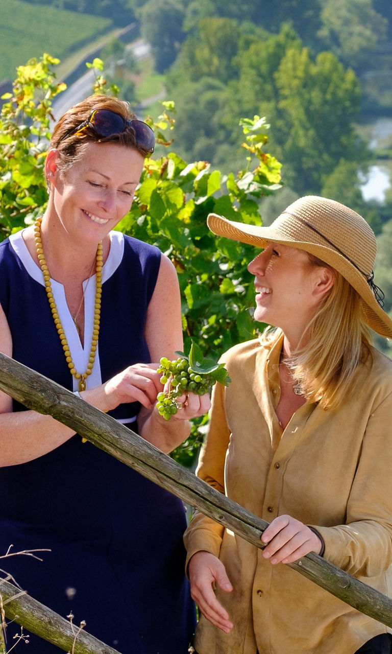 Two women in vineyard overlooking river