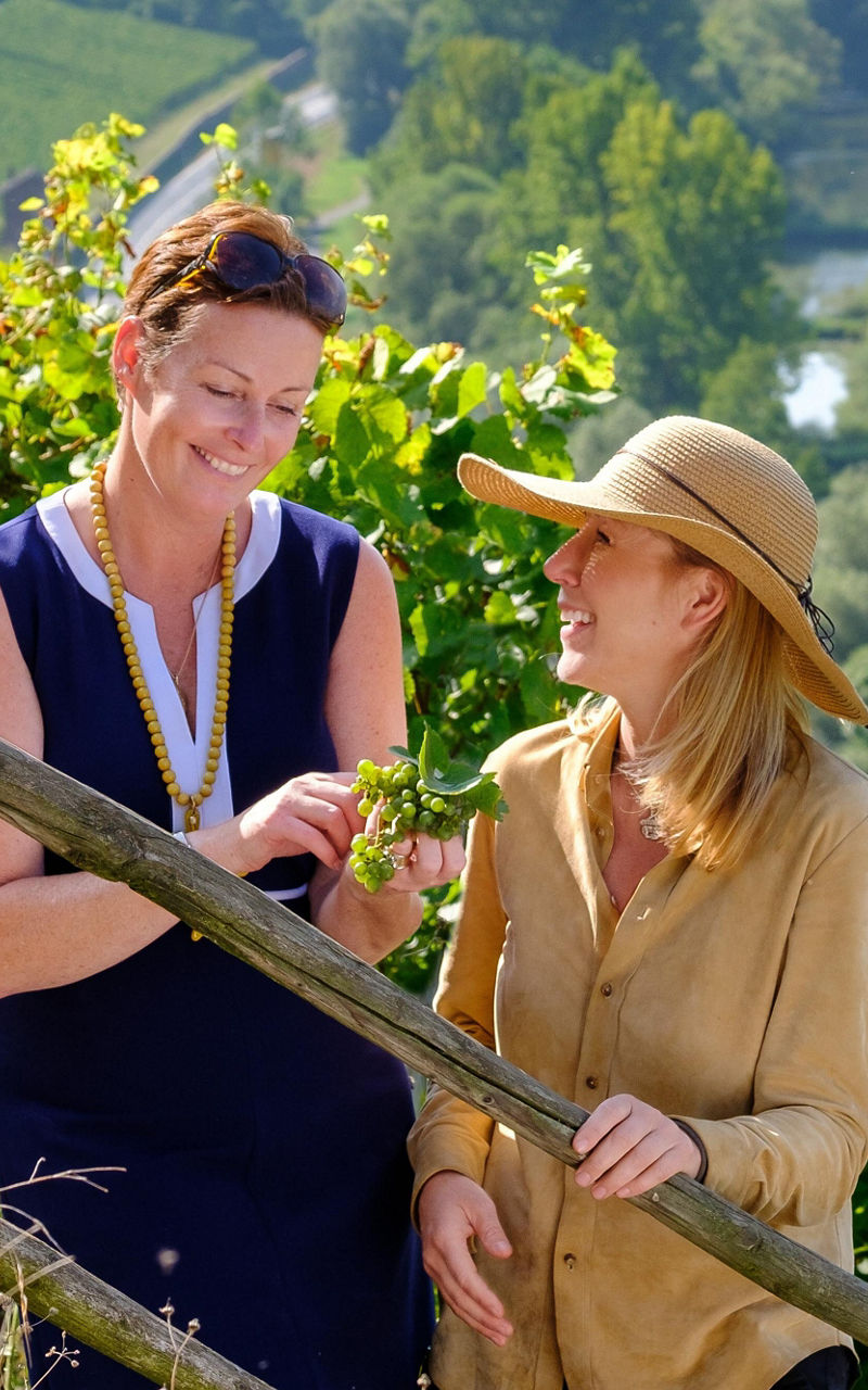 Two women in vineyard overlooking river