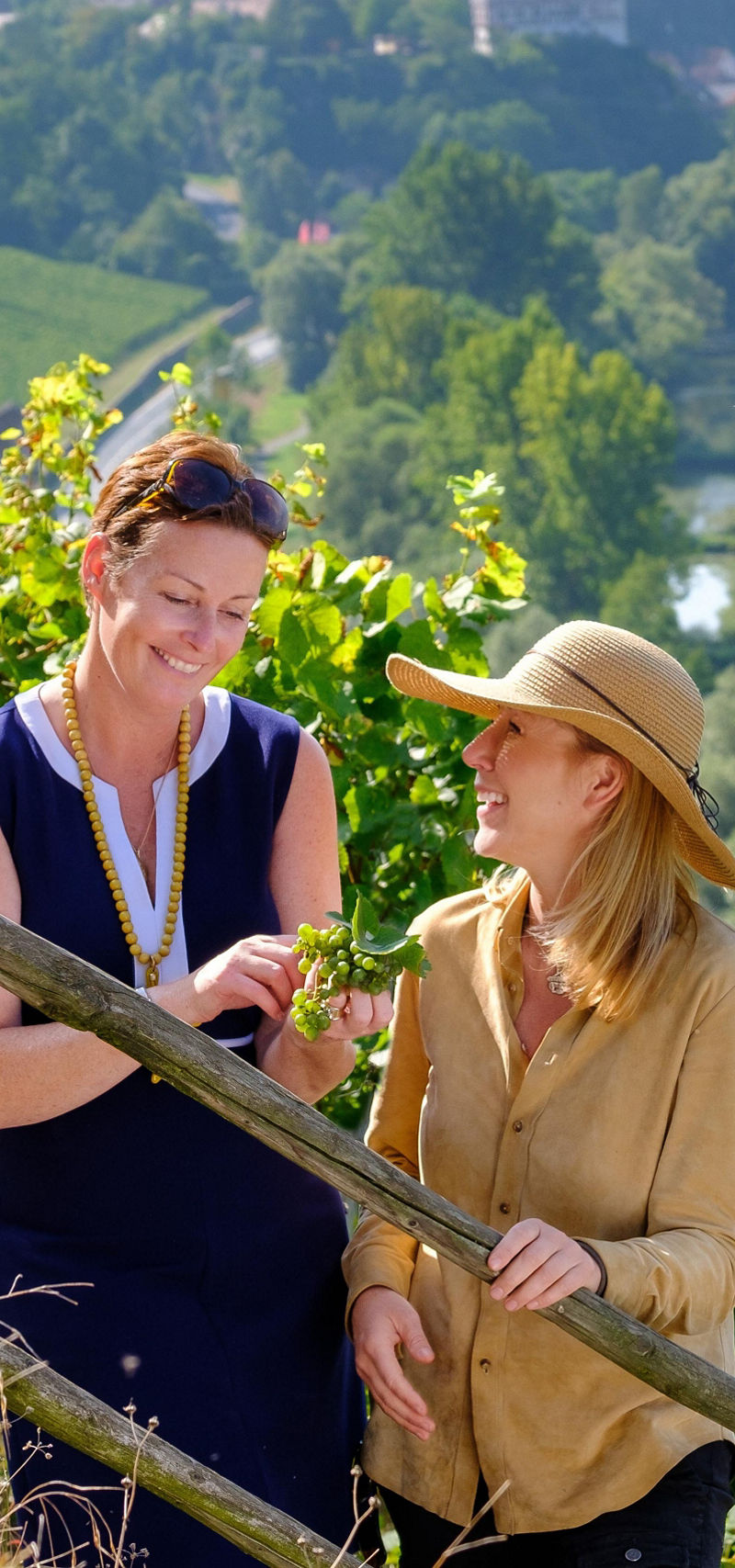 Two women in vineyard overlooking river