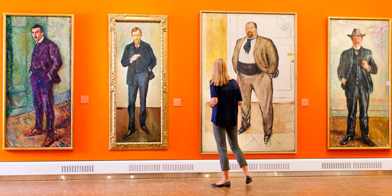 Woman admiring portraits in art gallery