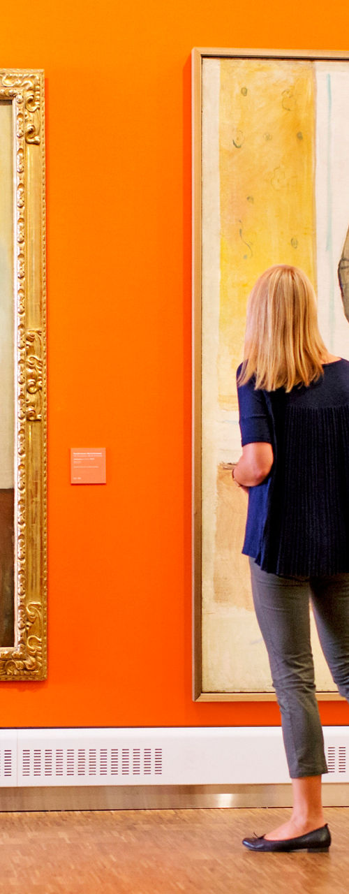 Woman admiring portraits in art gallery