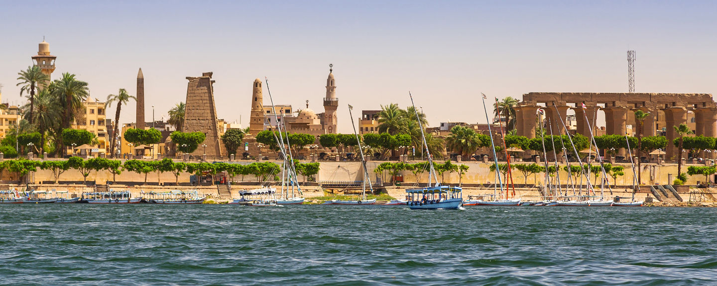 Luxor riverside with ancient ruins and boats