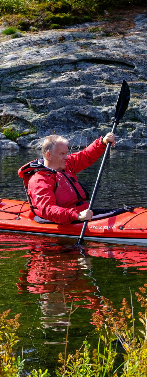 Two kayakers paddling in scenic lake